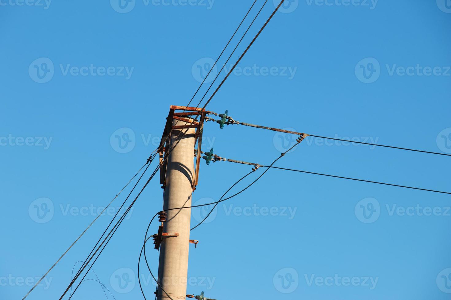 elektrisk Pol med en linjär tråd mot de blå himmel närbild. kraft elektrisk Pol. foto
