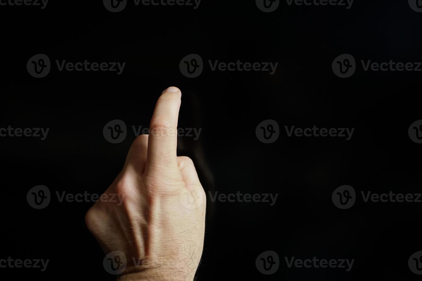 index finger pekande på de skärm, svart bakgrund foto