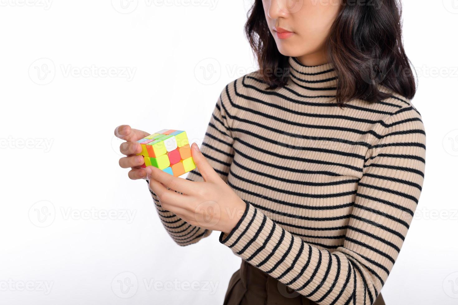 asiatisk kvinna innehav en rubik kub stående på vit bakgrund. lösning kubisk problem, problem lösning och framställning strategisk rör sig begrepp foto