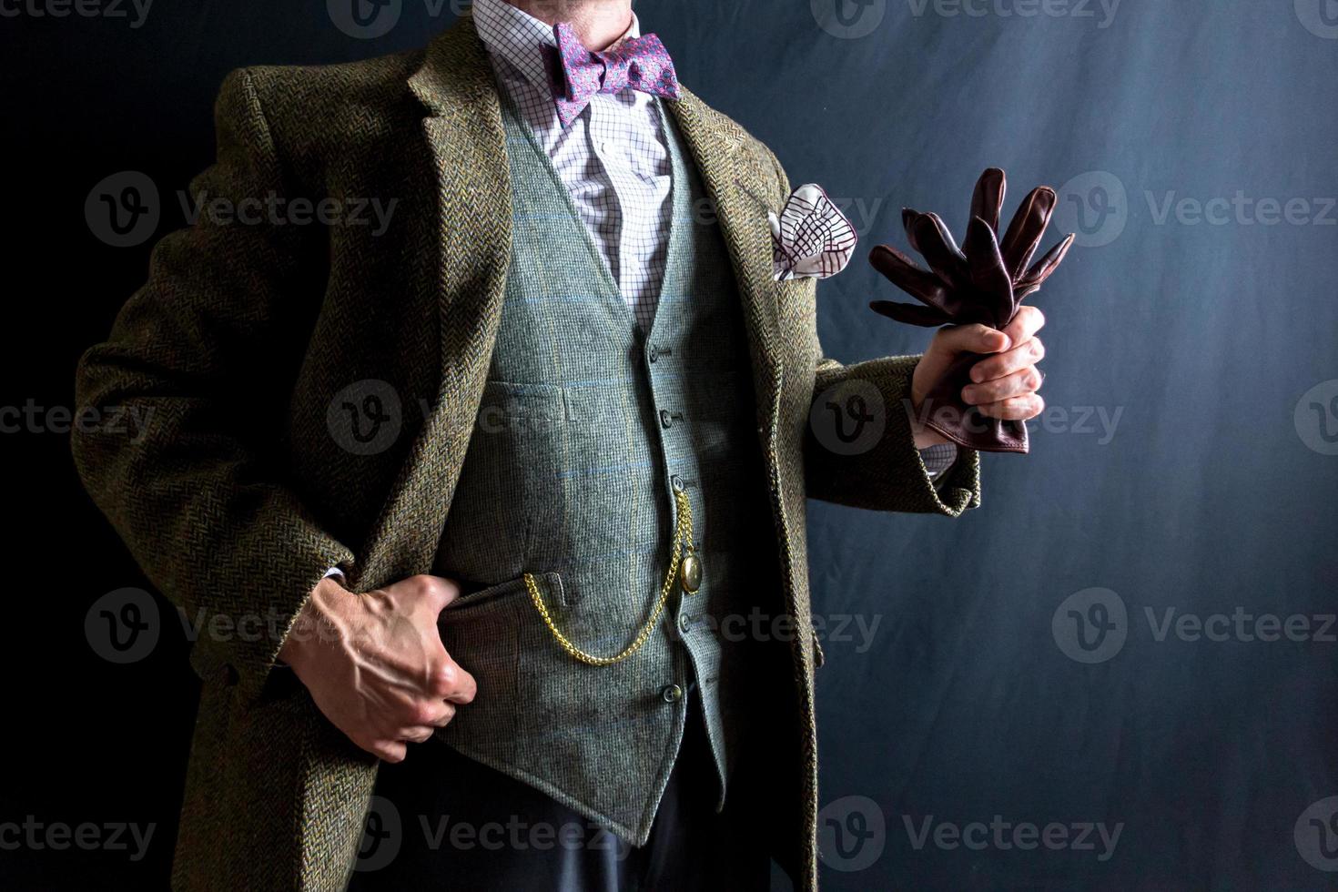 porträtt av herre i tweed kostym innehav läder handskar. begrepp av klassisk och excentrisk engelsk herre. årgång stil och retro mode. foto