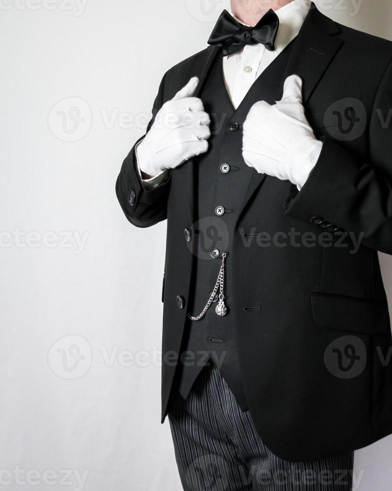 porträtt av butler i mörk kostym och vit handskar stående stolt. super butler på din service. begrepp av professionell gästfrihet. foto