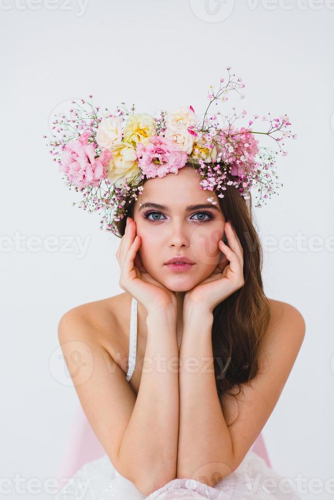 porträtt av skön brud med blomma krans på henne huvud på vit bakgrund foto