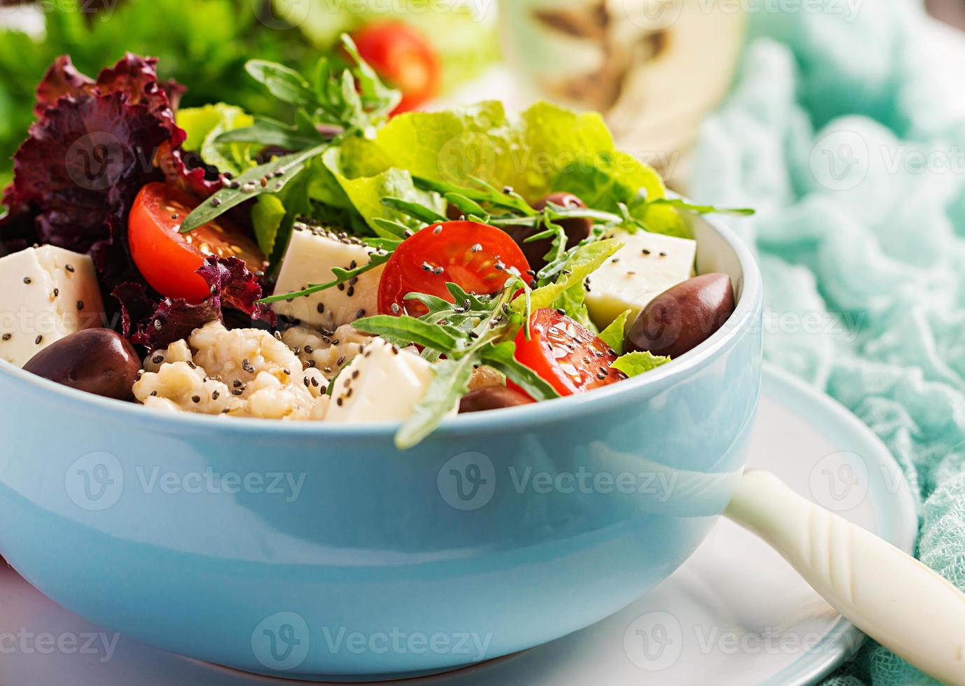 vegan sallad. frukost skål med gröt, tomater, ost, sallad, och oliver. friska mat. vegetarian buddha skål. foto