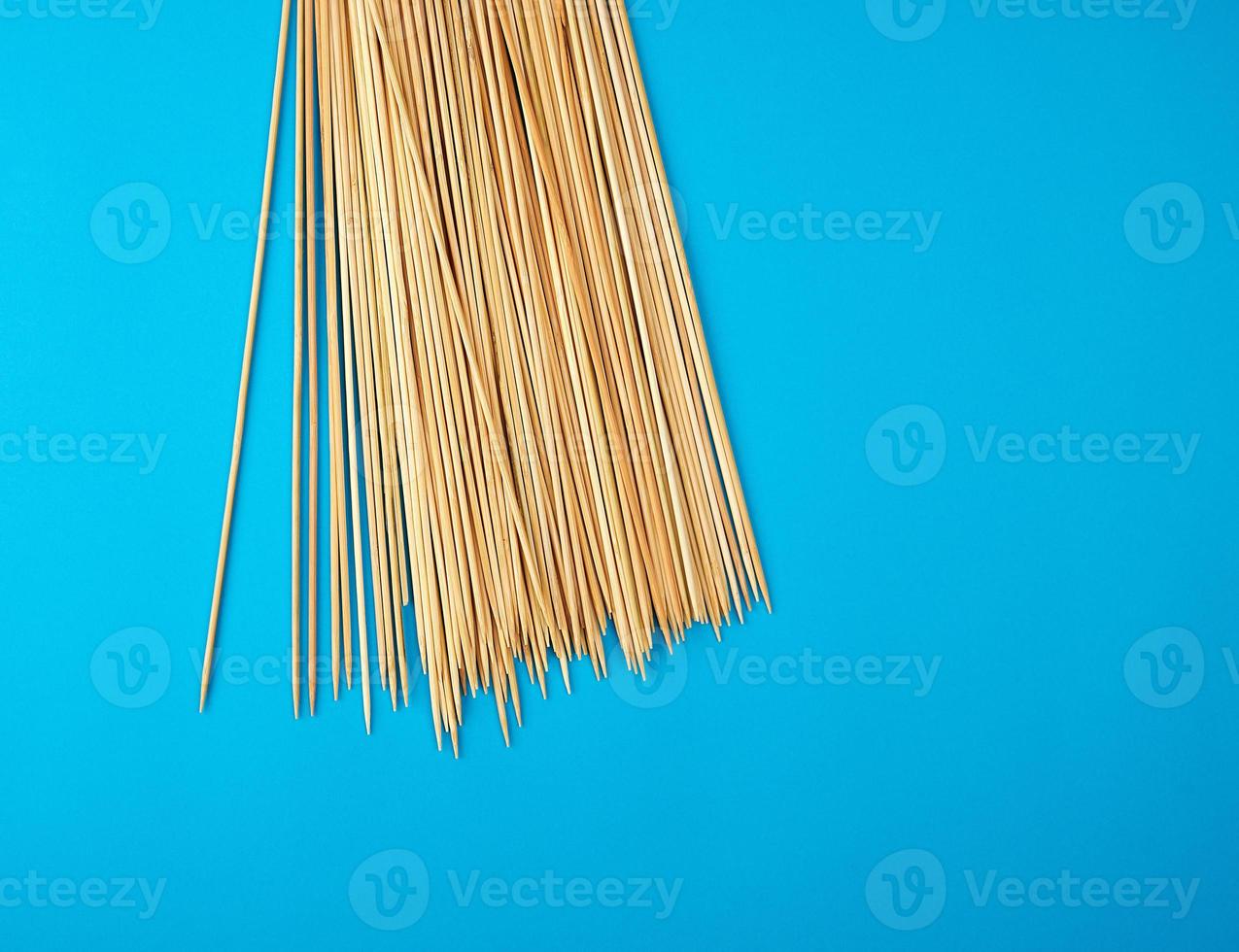 trä- bambu ätpinnar på en blå bakgrund foto