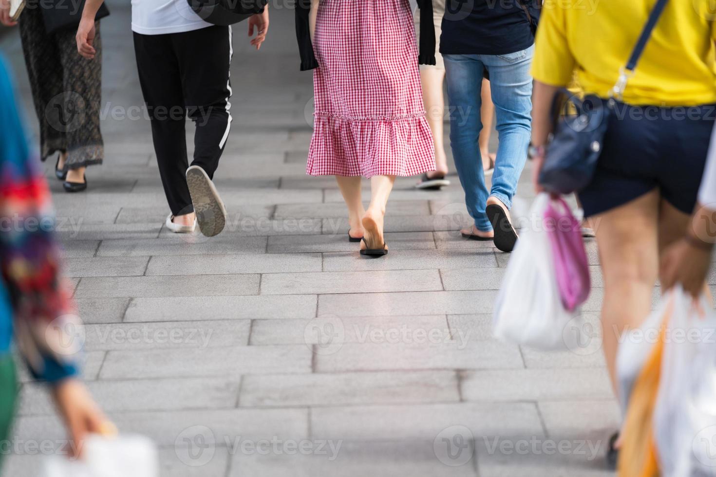 närbild på ben och skor som går på gatan i staden foto