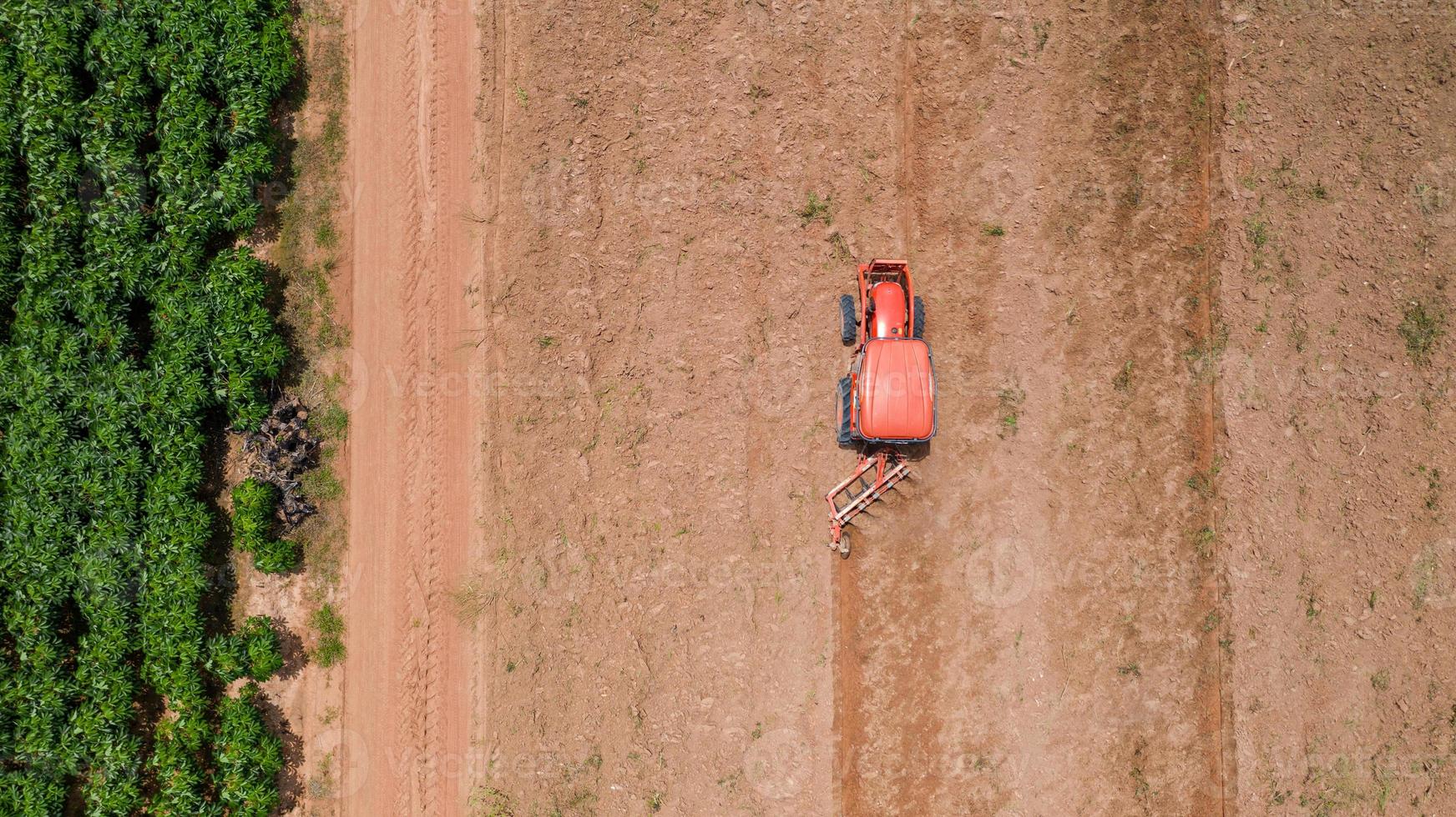 röd traktor i ett jordbruksfält foto