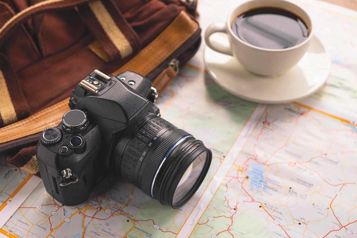 kamera och kaffe med en påse på en karta foto