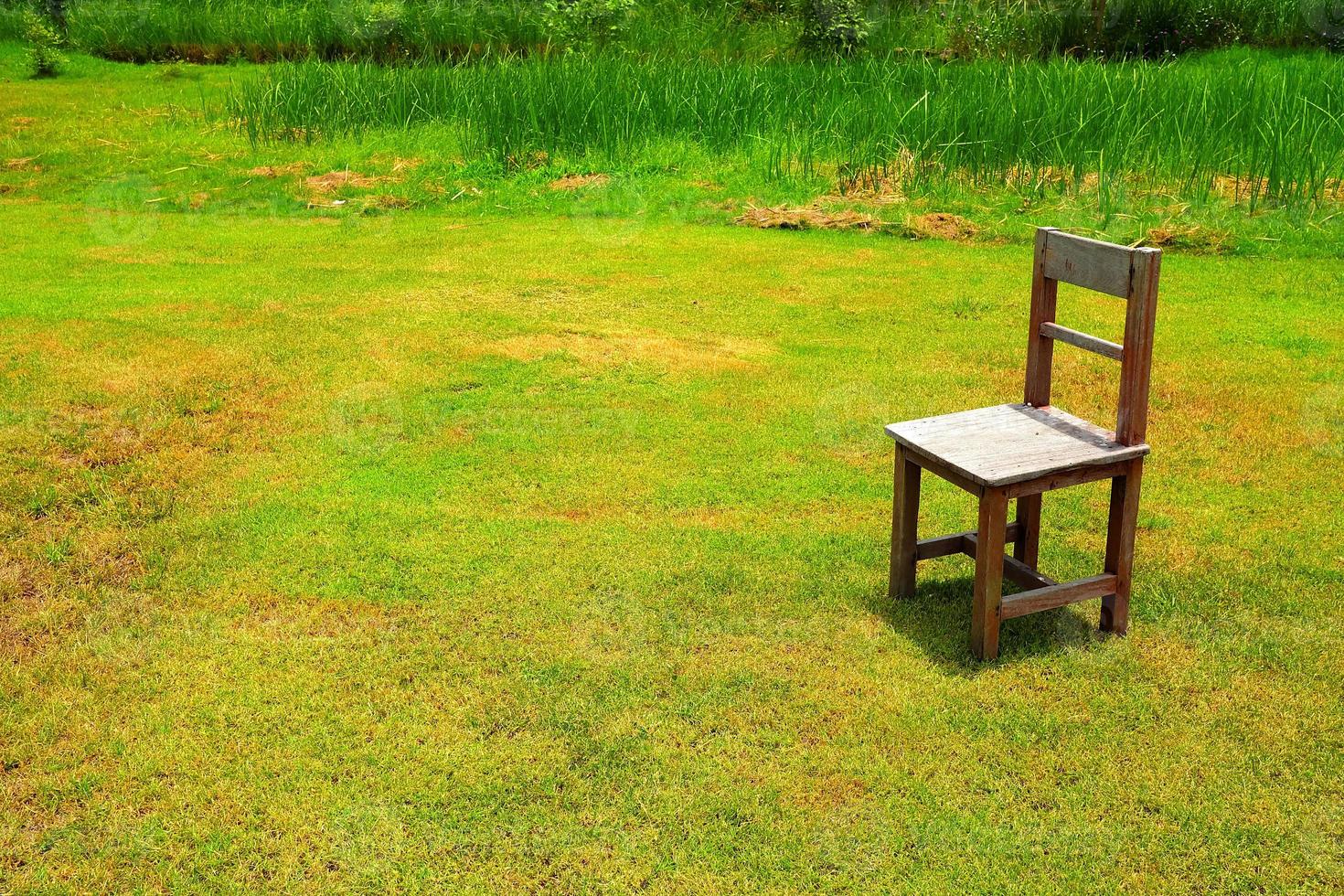 gammal trä- stol i grön fält. foto