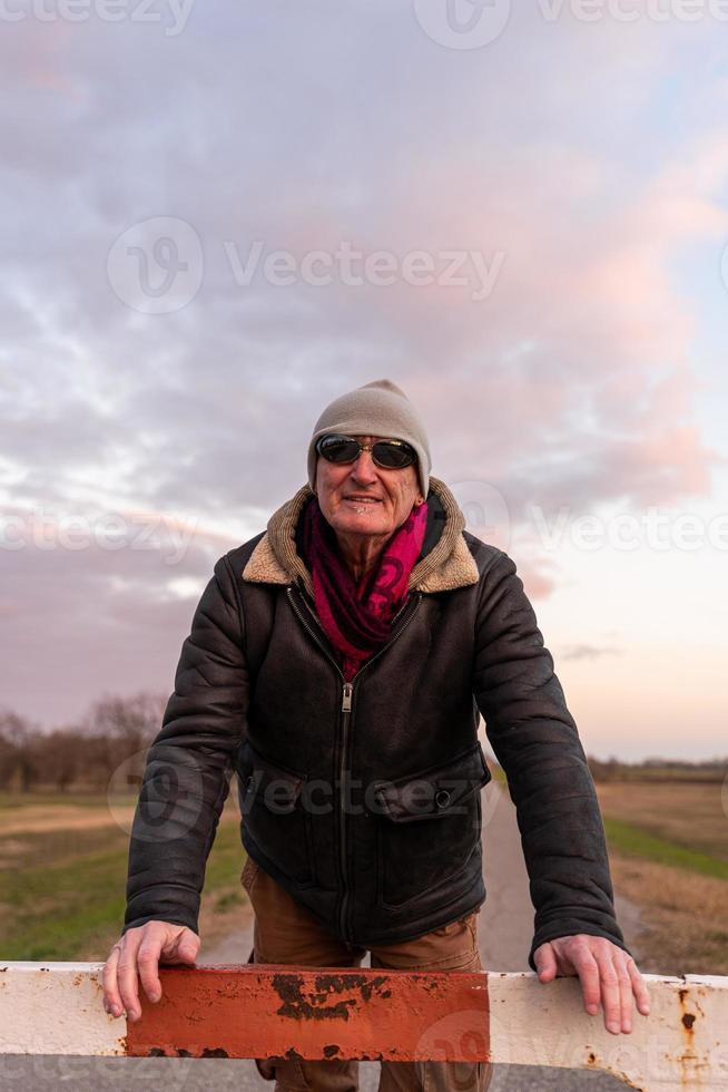 mitten åldrig man bär vinter- kläder tar en ha sönder i en Land väg foto