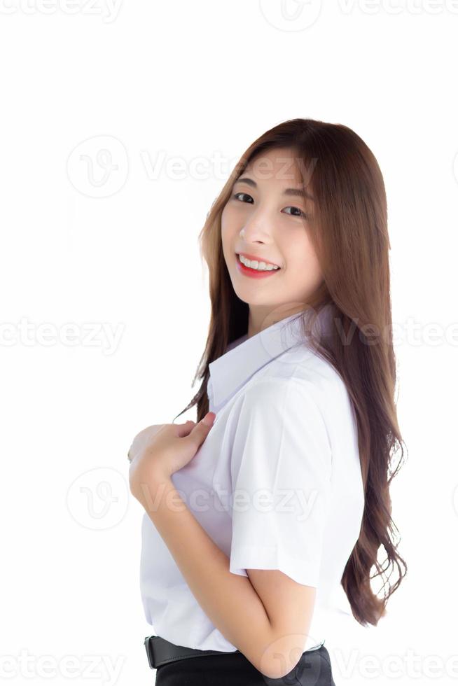 asiatisk porträtt av ett vuxen thai studerande i universitet studerande enhetlig. ung asiatisk skön flicka stående självsäkert isolerat på vit bakgrund. foto