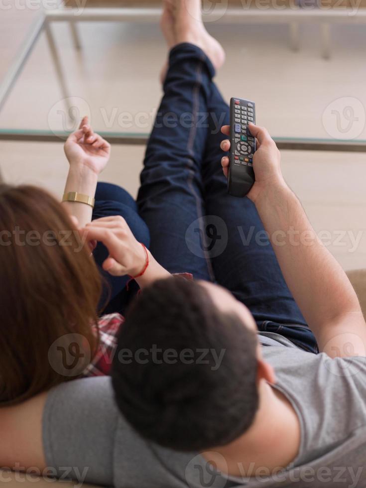 ungt par på soffan tittar på tv foto