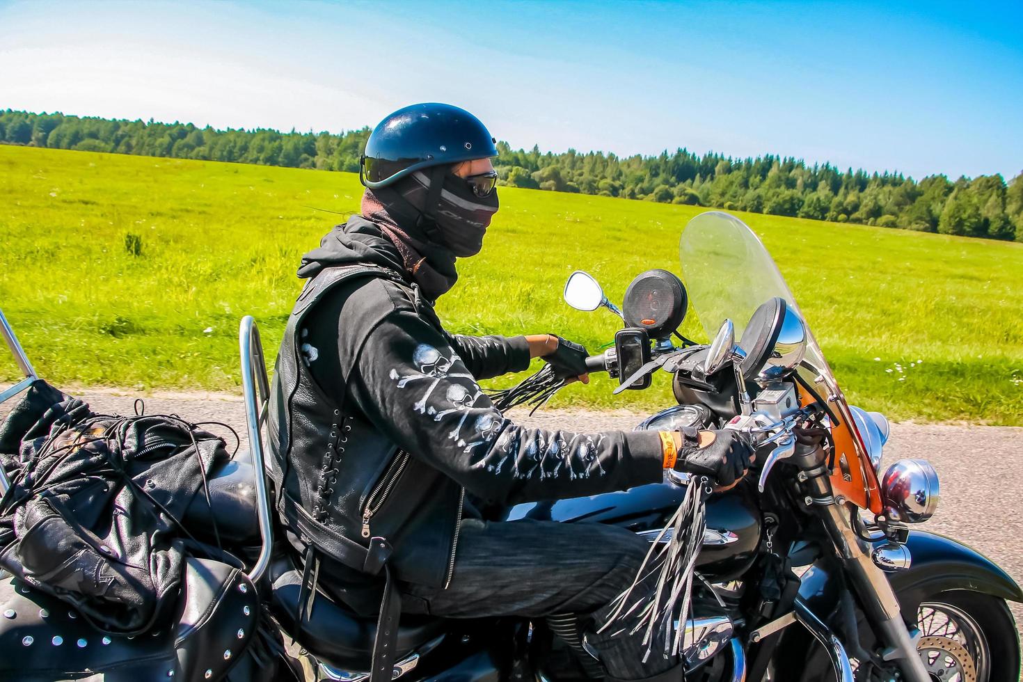 motorcyklist rider längs de väg på en sommar solig dag. cyklist på en motorcykel. foto