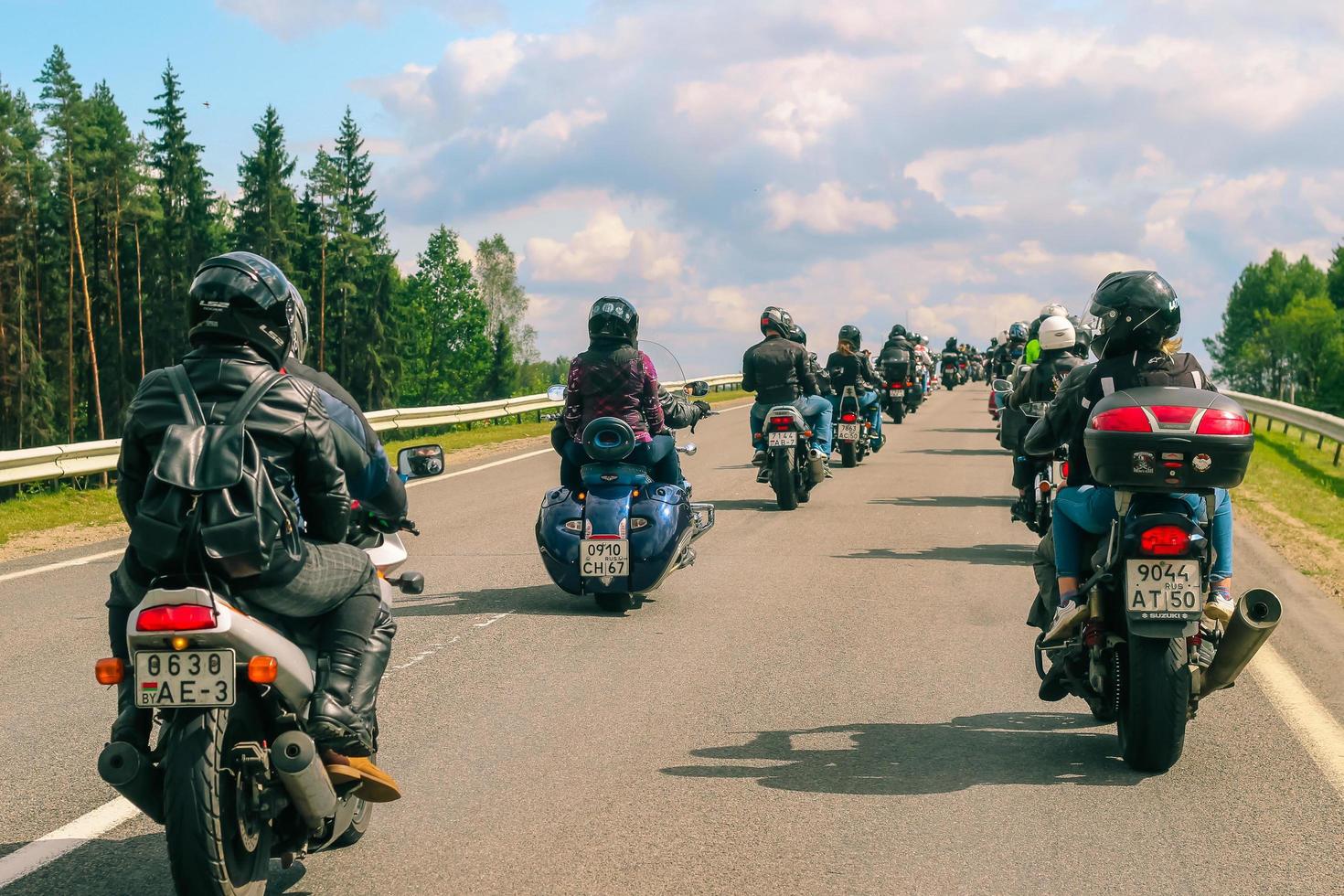 grupp av motorcyklister rider på asfalt Land väg på sommar solig dag. parad av motorcyklar. foto