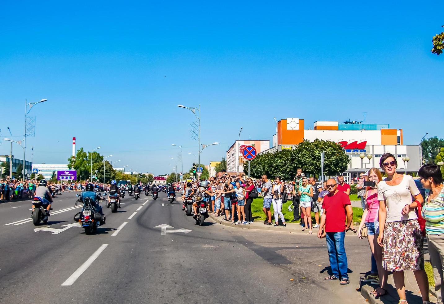 folkmassan av människor hälsar en grupp av motorcyklister på gata i stad. motorcykel parad på sommar solig dag. foto