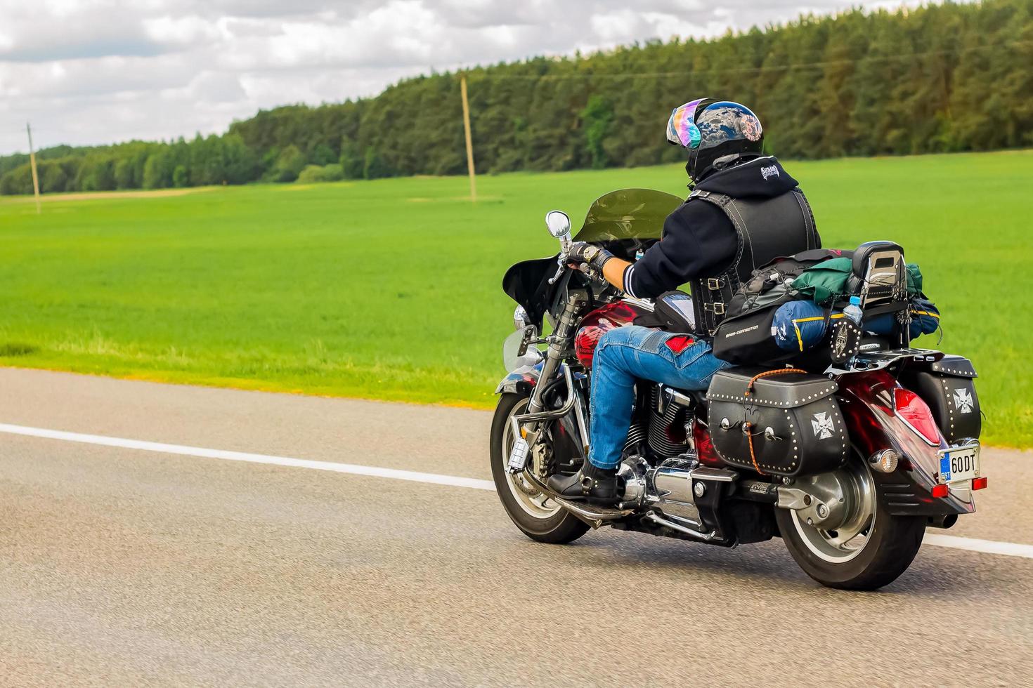 motorcyklist rider längs de väg på en sommar solig dag. cyklist på en motorcykel. foto