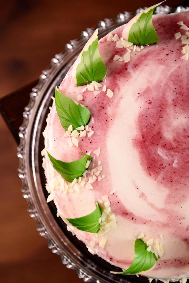 rosa tårta dekorerad med gröna godisblad foto