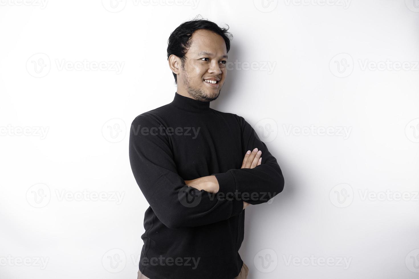 ett asiatisk ung självsäker man Framställ med korsade ärm mot en vit bakgrund. foto