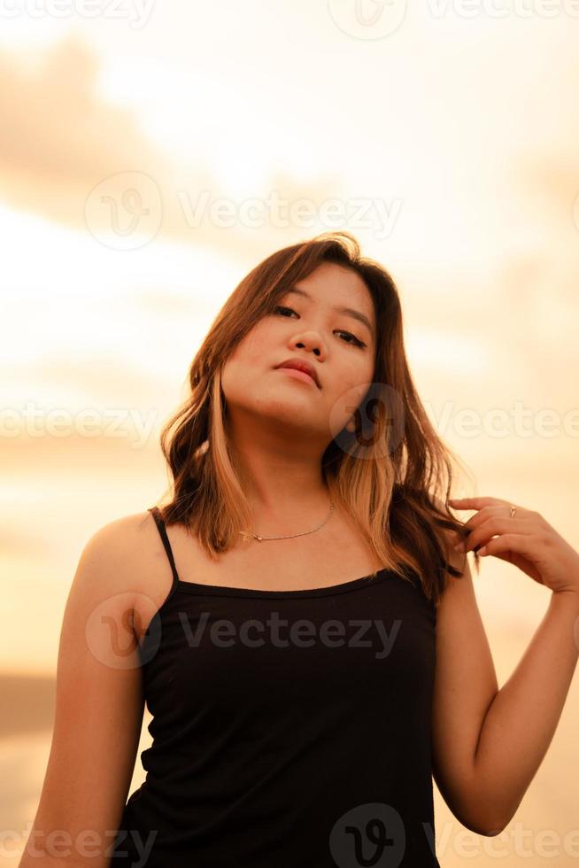 porträtt av ett indonesiska kvinna i svart kläder och blond hår Framställ mycket vackert på de strand foto