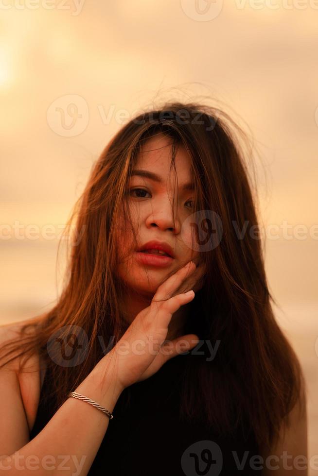 en skön och sexig asiatisk kvinna med platt ansiktsbehandling uttryck och Framställ med hans hand under hans haka foto