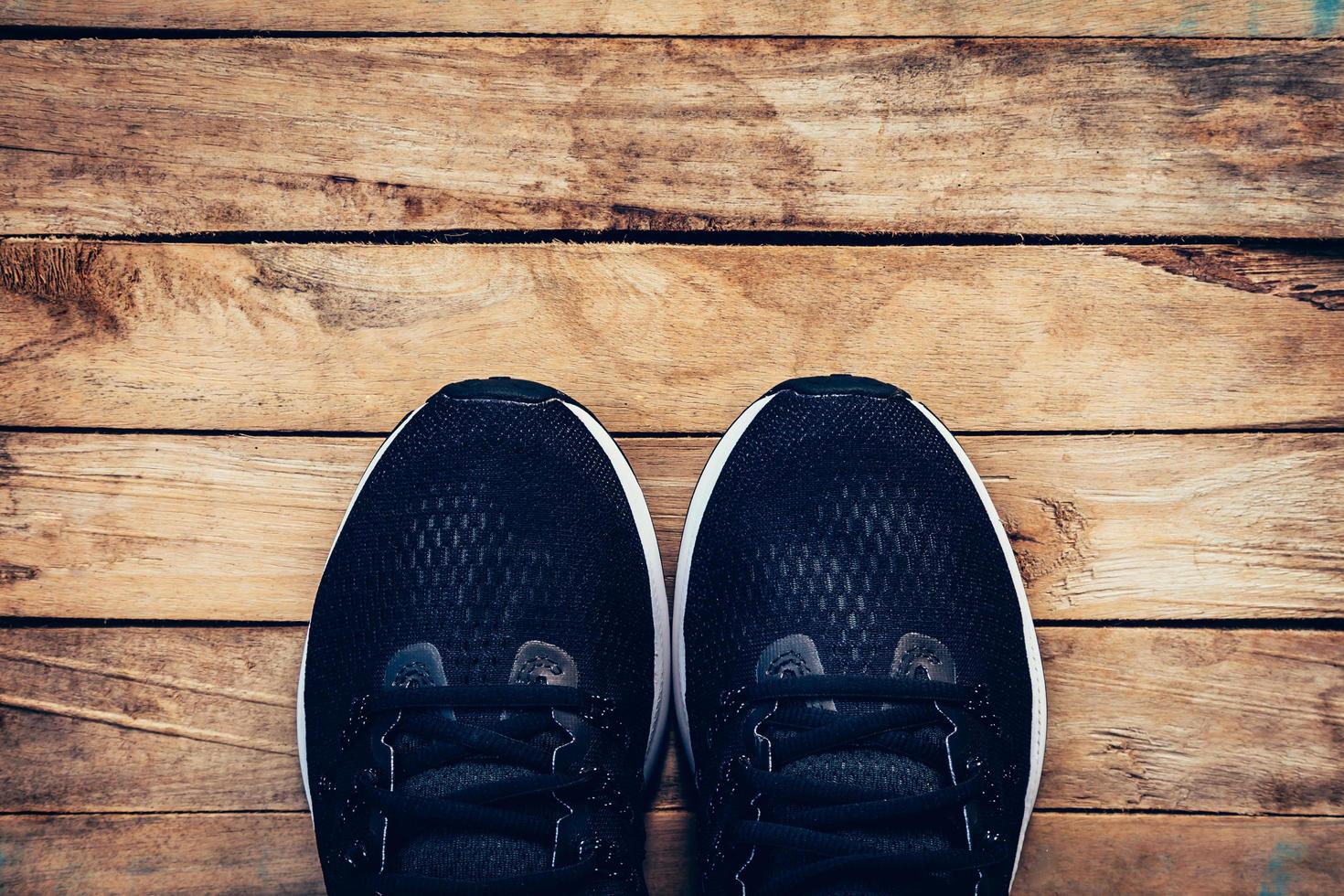 svart skor tillfällig och gymnastiksko på trä bakgrund med Plats. foto