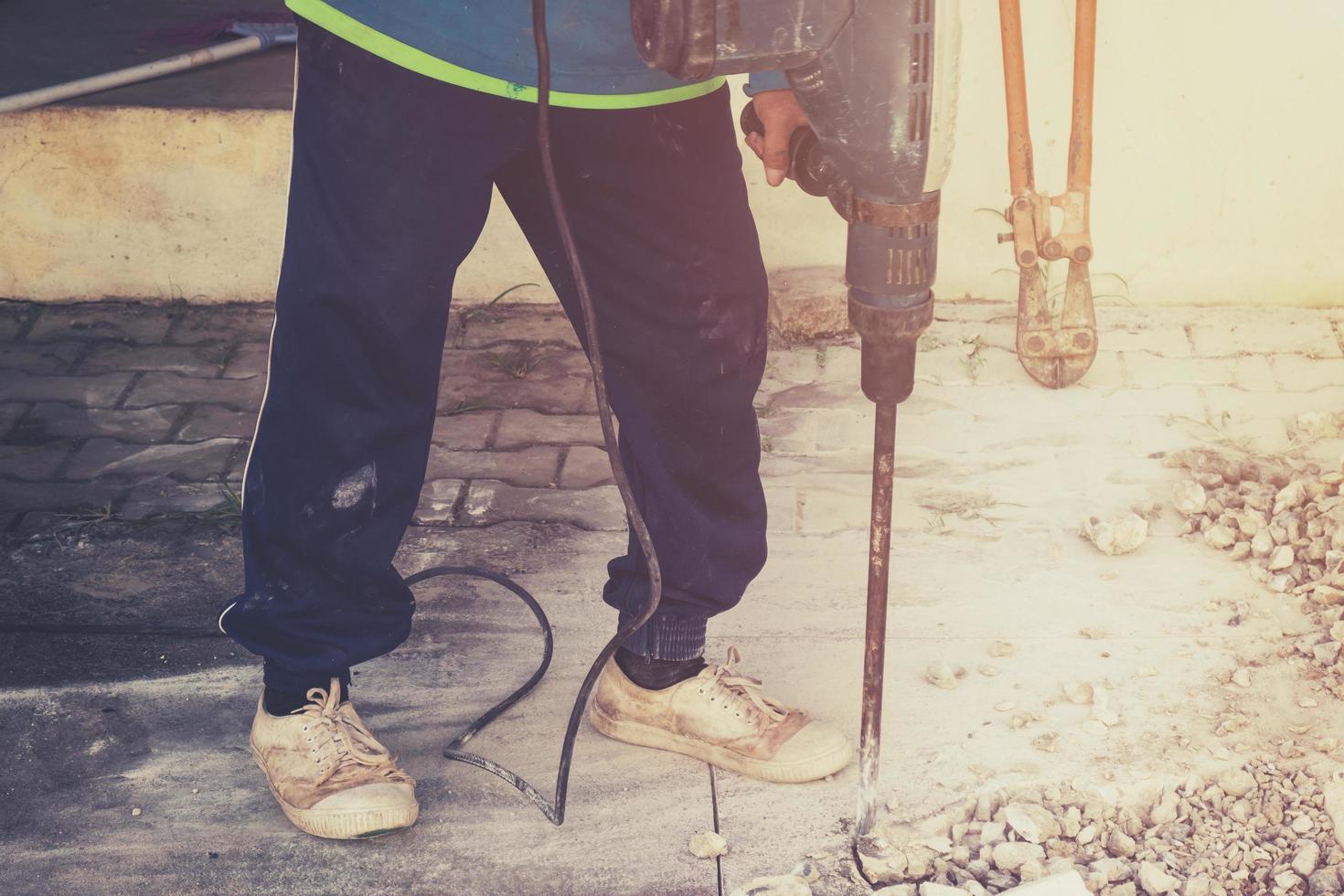 stänga upp arbetstagare man murare borrning cement betong golv med maskin foto