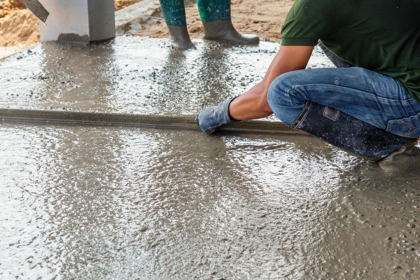 man murare byggnad en golv täcka cement på golv foto