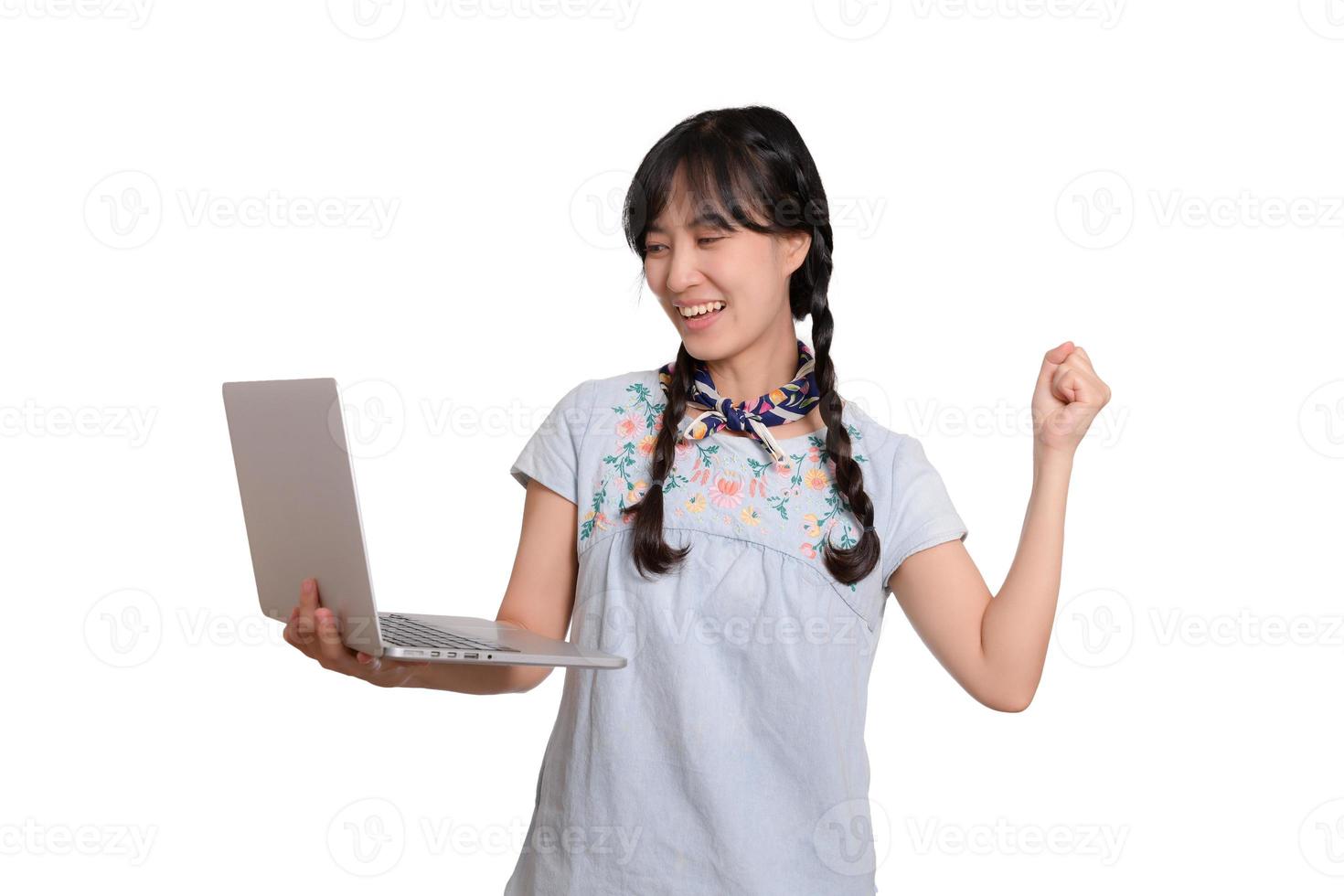 porträtt av skön Lycklig ung frilans asiatisk kvinna i denim klänning använder sig av bärbar dator arbete med Framgång på vit bakgrund foto