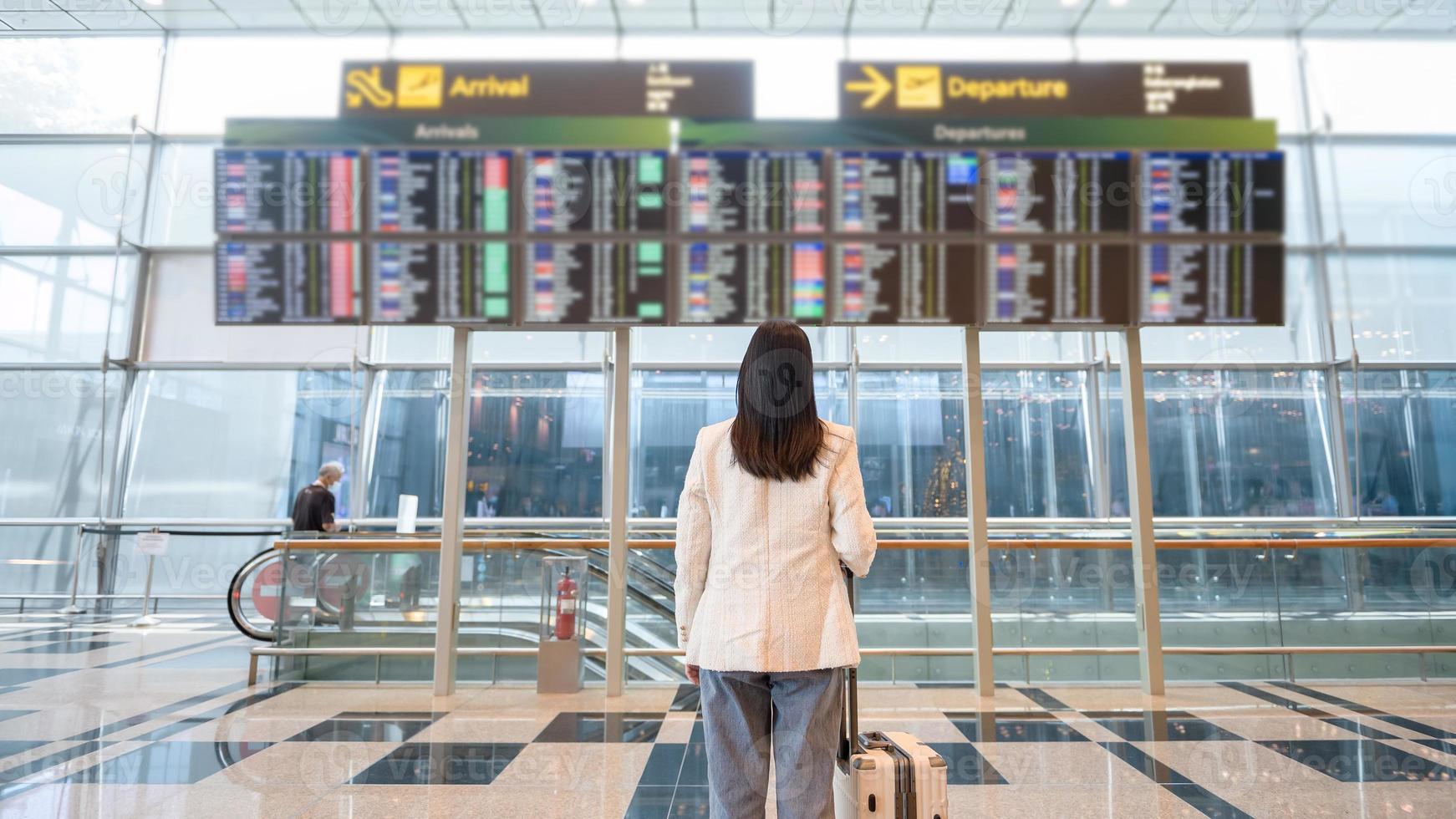 en ung kvinna med resväska , kolla upp i på internationell flygplats , semester resa och transport begrepp foto