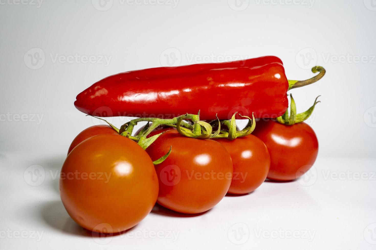 Foto färsk grönsaker tomat och chili paprikor på vit isolerat bakgrund