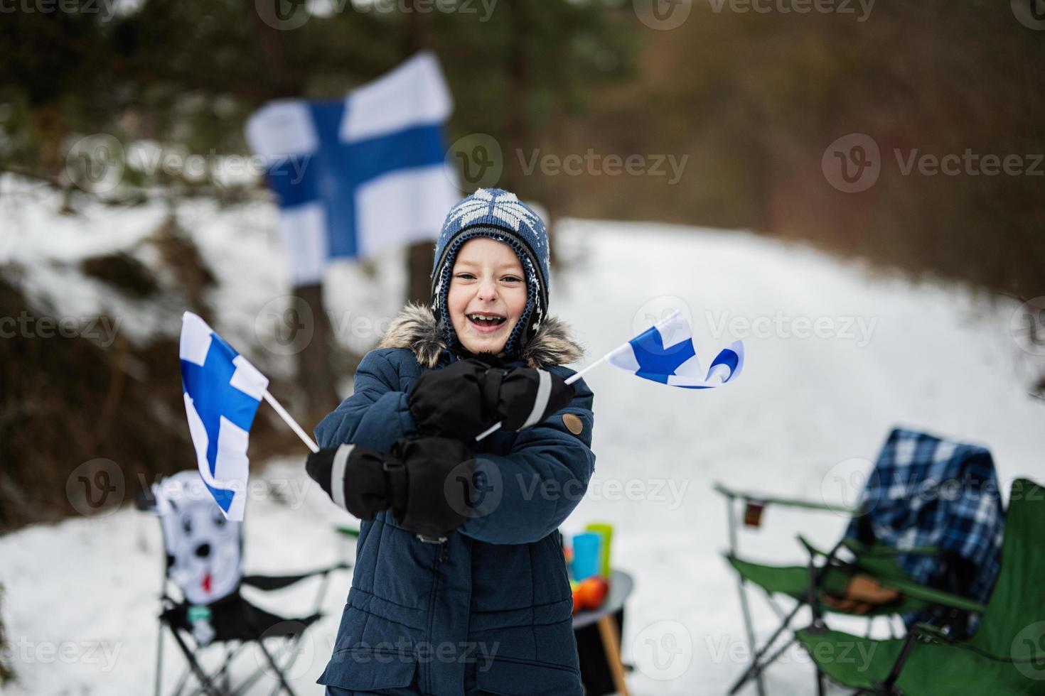 finska pojke med finland flaggor på en trevlig vinter- dag. nordic scandinavian människor. foto