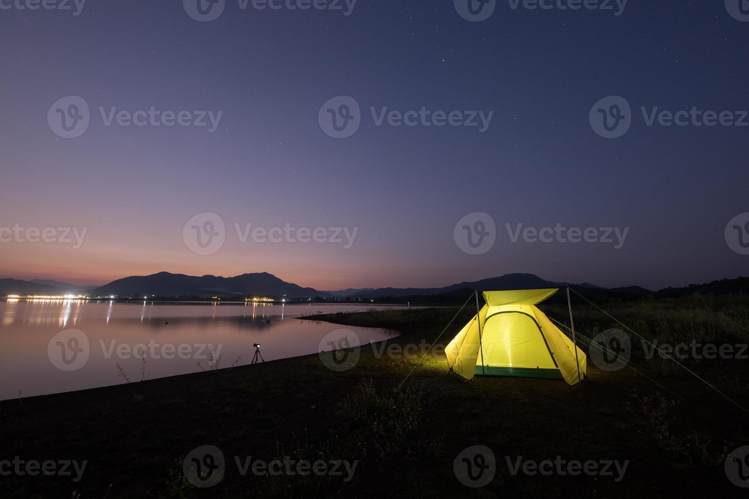 campingtält nära vatten i skymningen foto