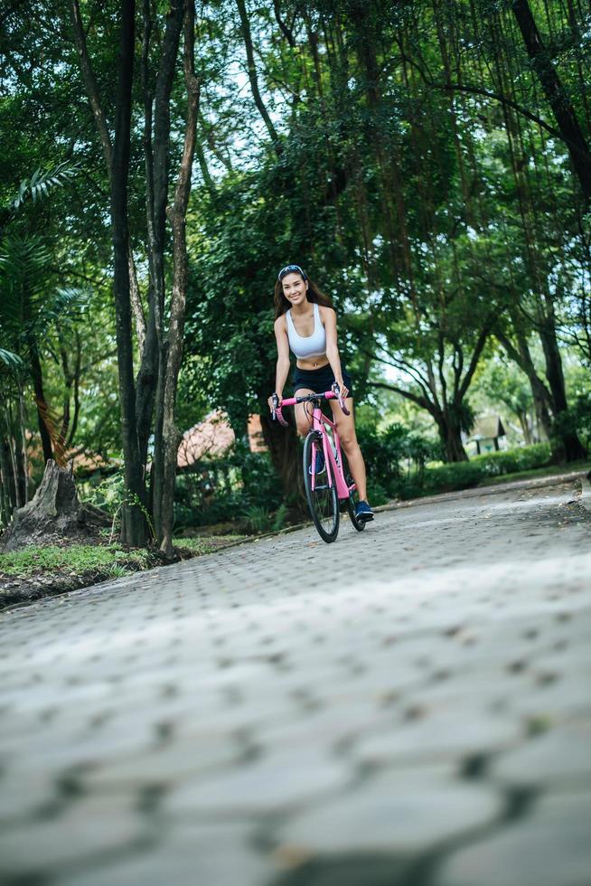 ung kvinna som cyklar i parken foto