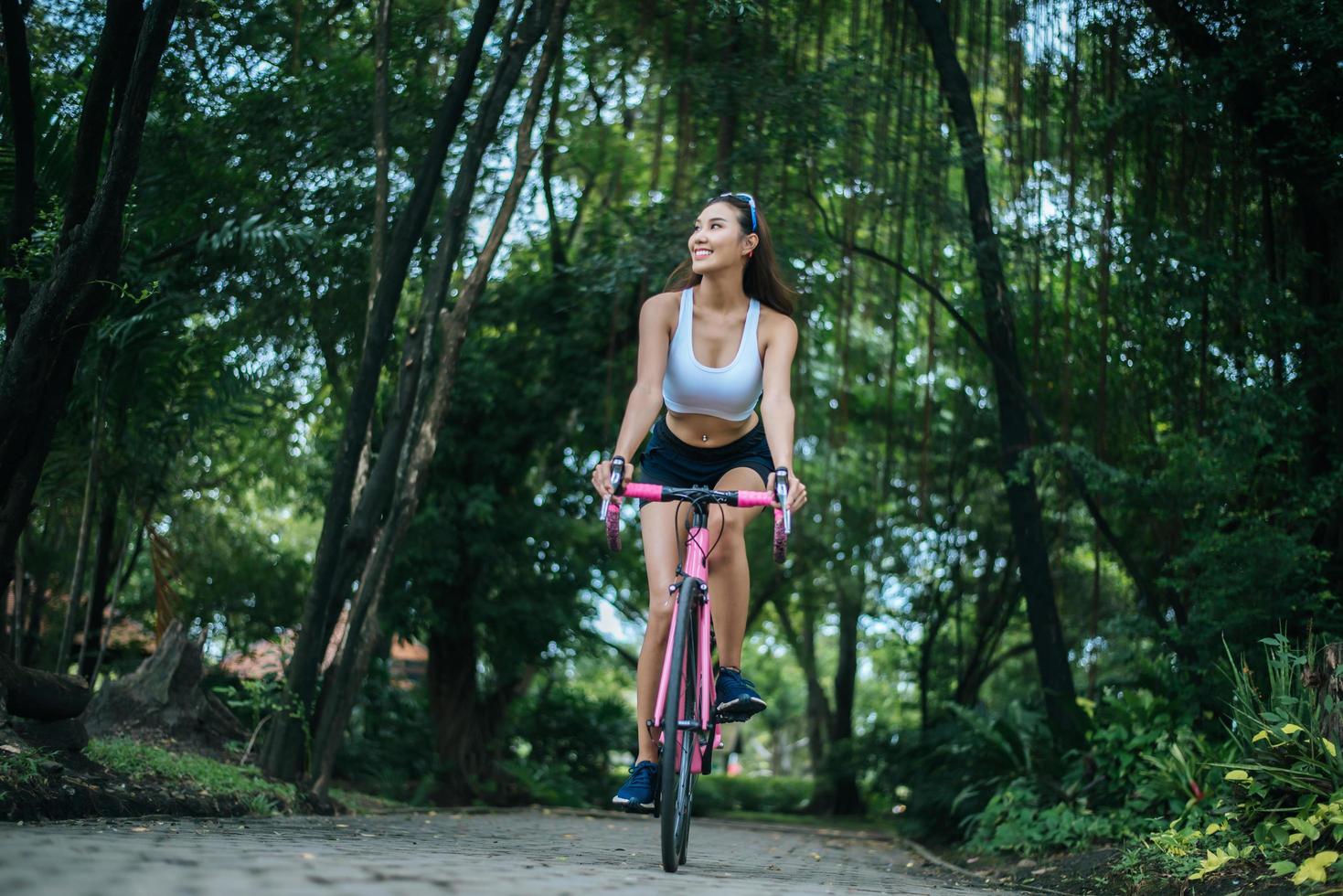 ung kvinna som cyklar i parken foto