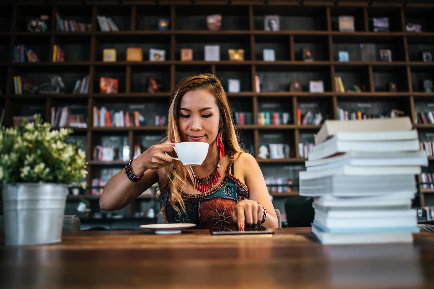 kvinna som dricker cappuccino och läser en bok foto
