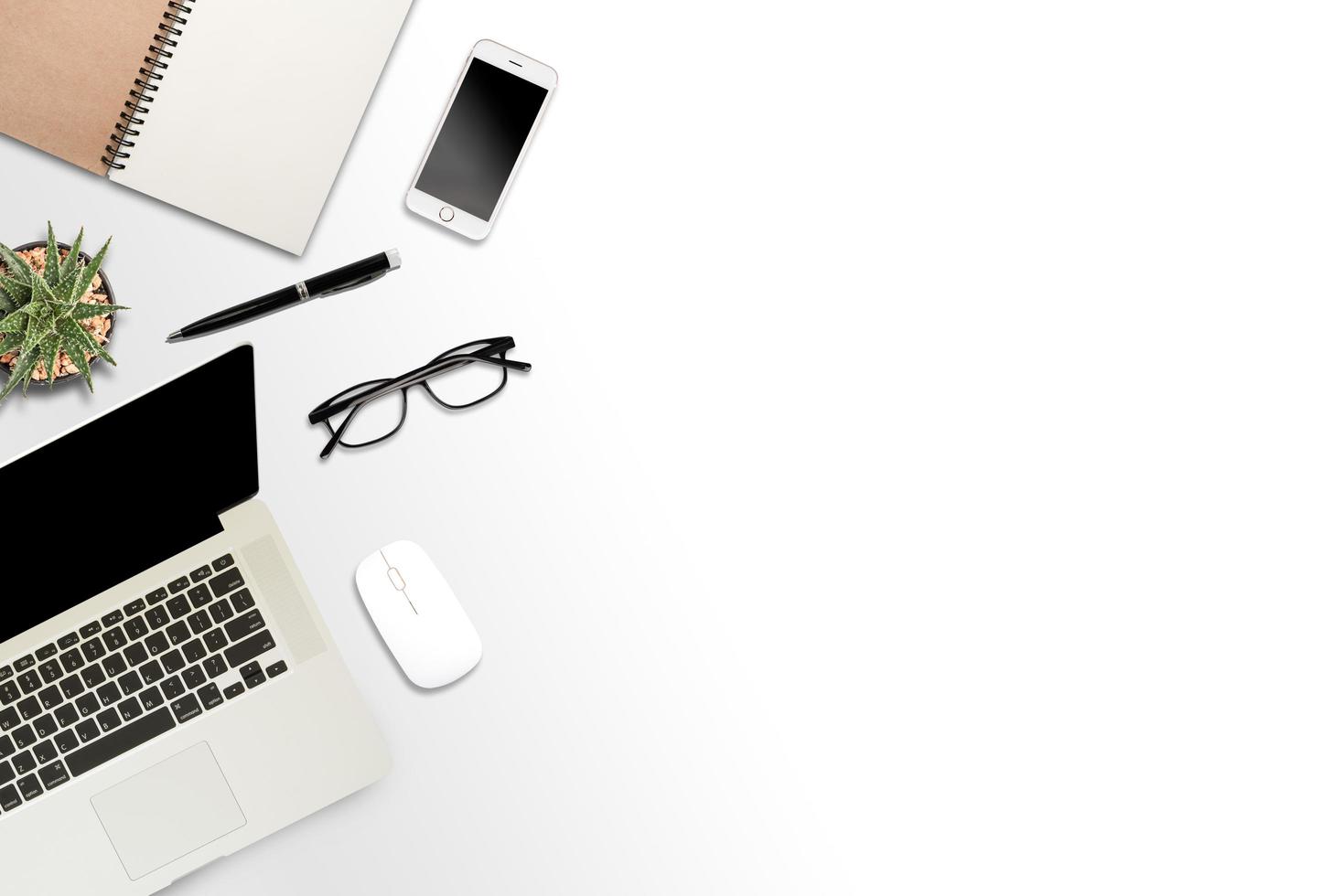 vit bakgrund med bärbar dator, smartphone och anteckningsbok foto