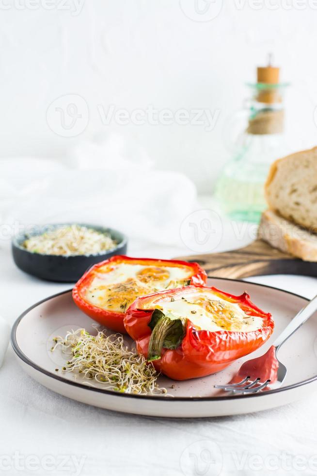 klocka peppar halvor bakad med ägg och mikrogrönsaker på en tallrik på de tabell. flexitär organisk diet. vertikal se. kopia Plats foto