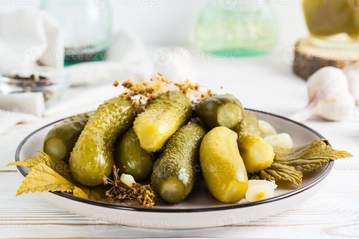 klar att äta inlagd gurkor på en tallrik och Ingredienser för matlagning på en trä- tabell. hemlagad snacks. foto