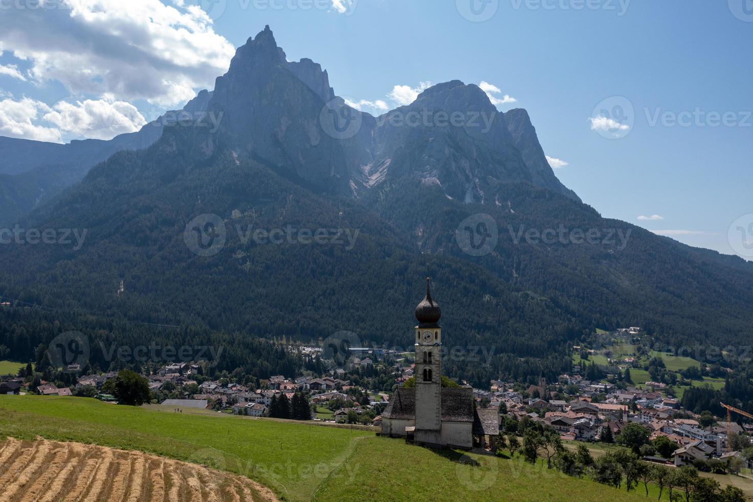 st. valentin kastelruth by kyrka i de sommar i de dolomit alperna. Fantastisk landskap med små kapell på solig äng och petz topp på kastelruth kommun. dolomiterna, söder tyrolen, Italien foto