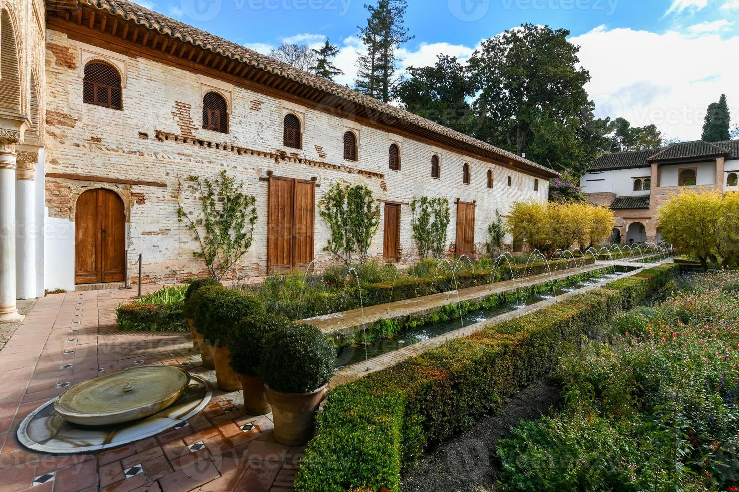 se av de generalife gård, med dess känd fontän och trädgård genom ett båge. alhambra de granada komplex på granada, spanien, Europa på en ljus vinter- dag. foto