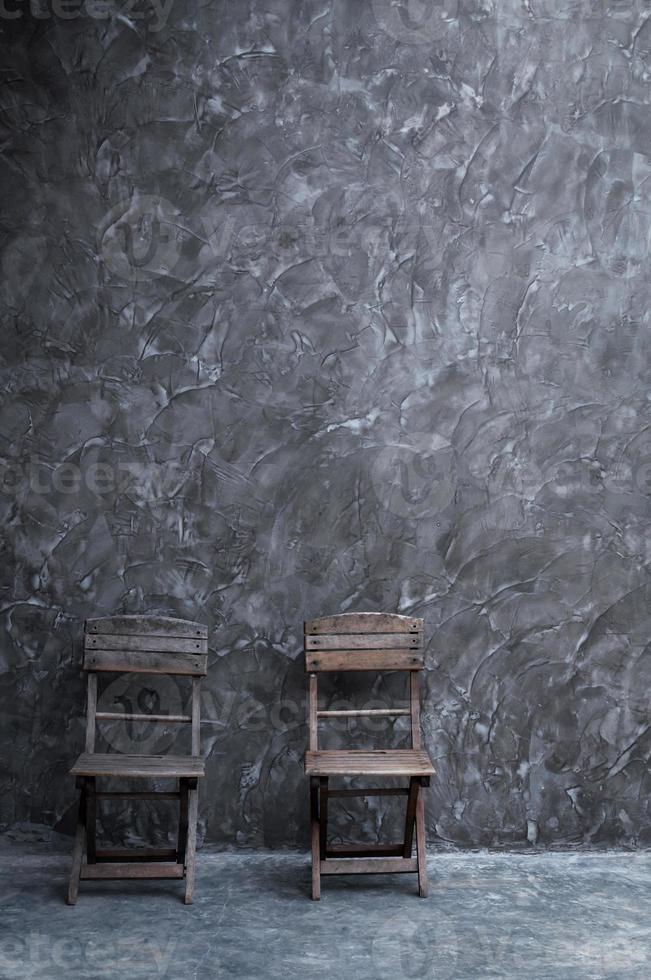 gammal årgång stol trä- på mörk betong vägg textur foto