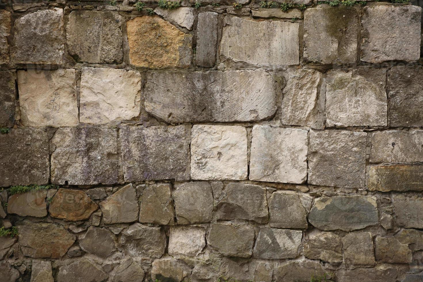 textur av sten vägg med många stor brun stenar foto