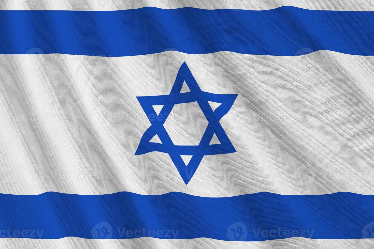 Israel flagga med stor veck vinka stänga upp under de studio ljus inomhus. de officiell symboler och färger i baner foto