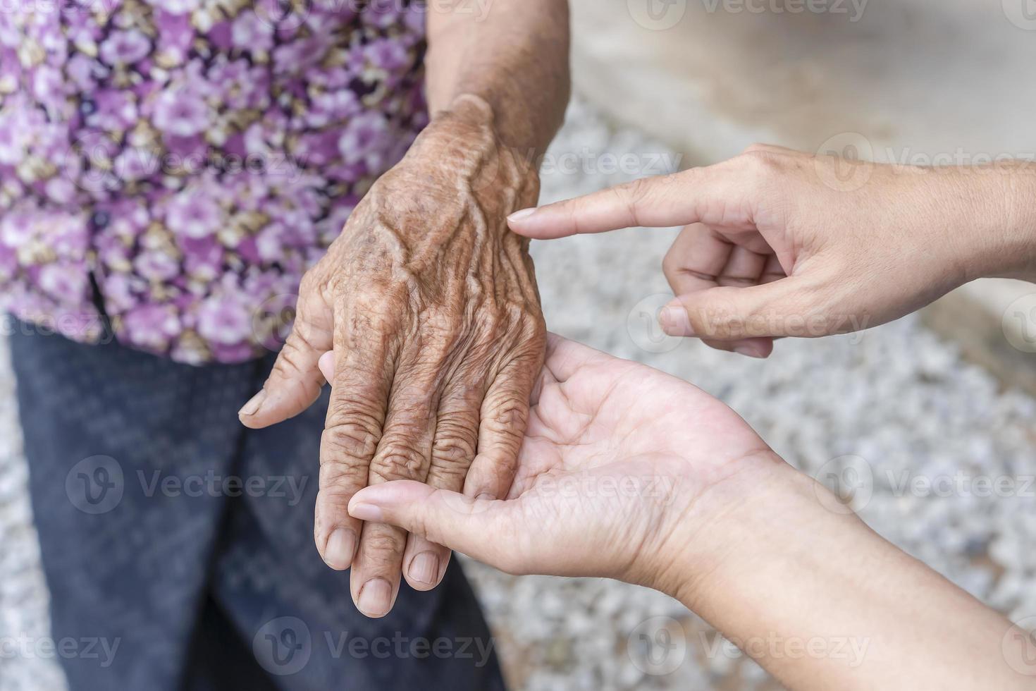 dotters fingrar poäng till rynkig hand. åldring bearbeta - mycket gammal senior kvinnas händer rynkig hud, effekt av ålder på de hud, gammal ålder. rynkig hud och framträdande ådror. äldre kvinnas händer foto