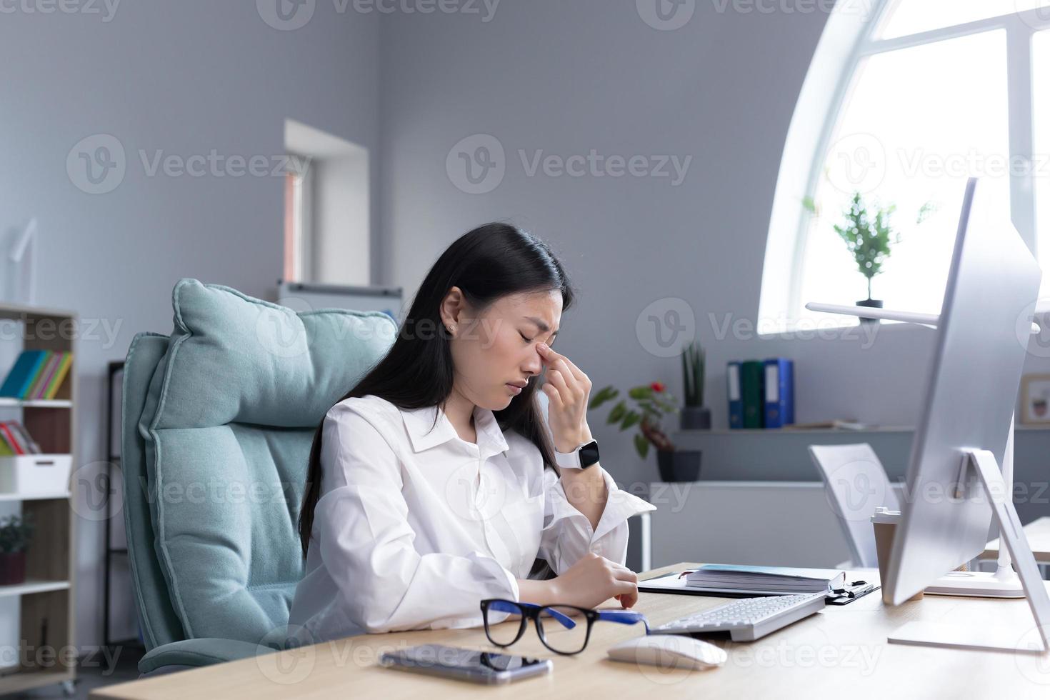 utmattning på arbete. trött ung asiatisk kvinna, affärskvinna, chef, revisor foto