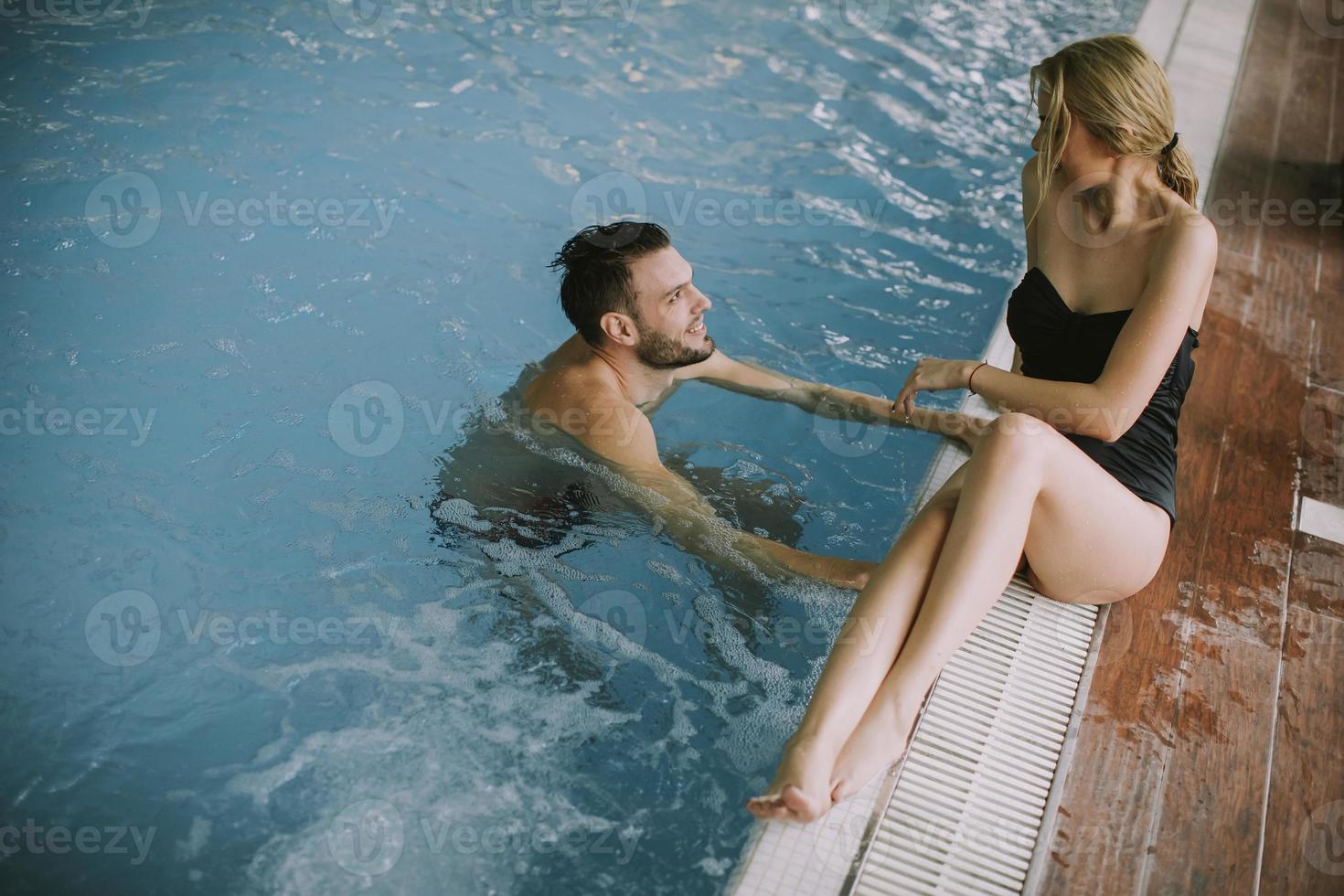 ungt par som kopplar av vid poolen av den inre poolen foto