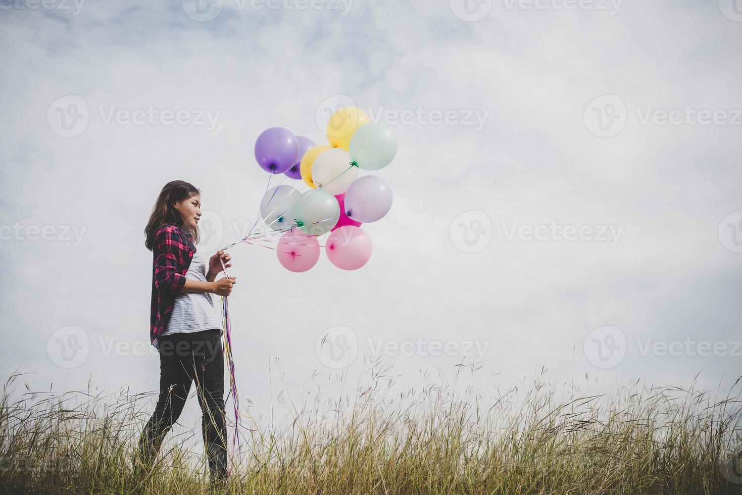 vacker ung hipster kvinna med färgglada ballonger utomhus foto