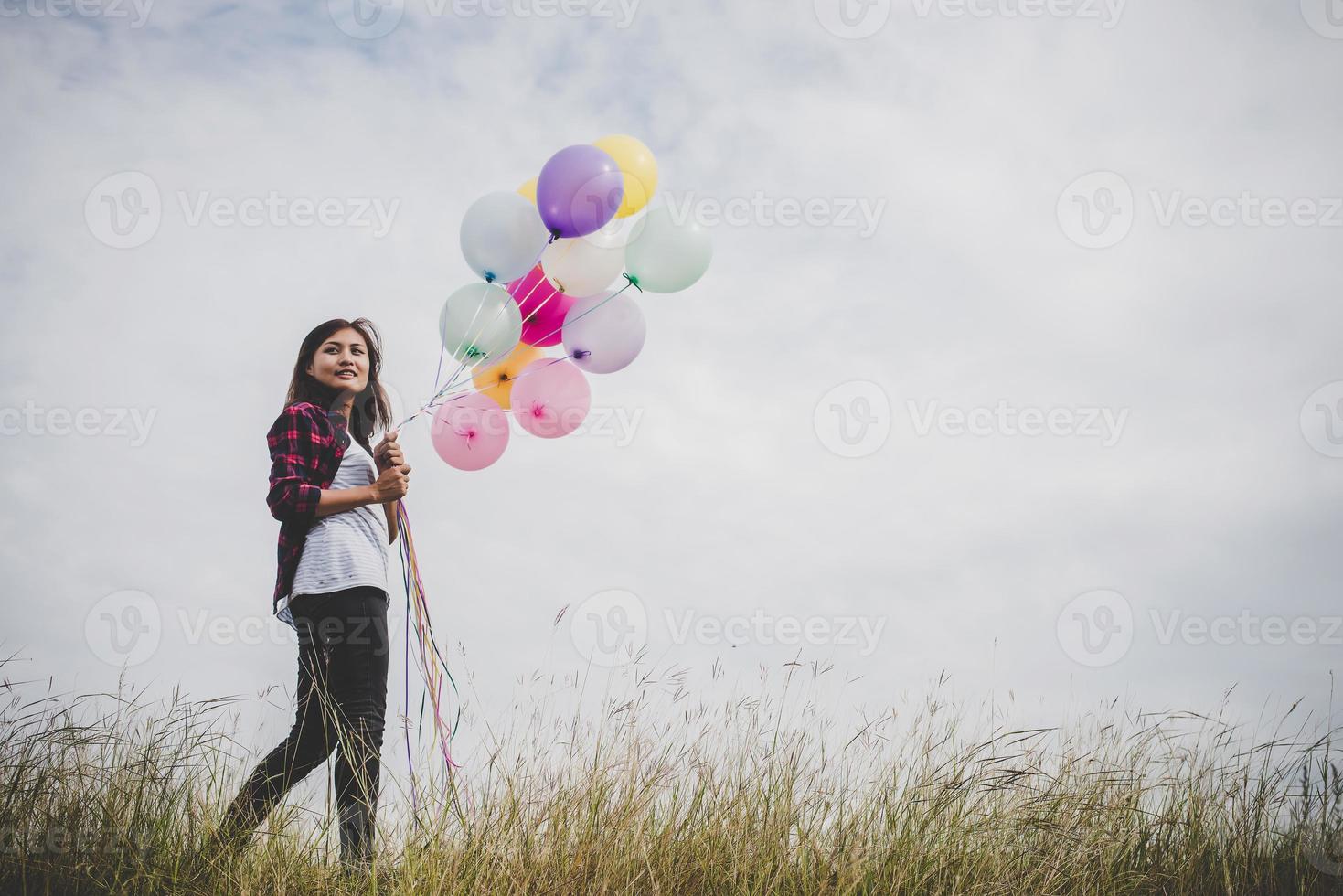 vacker ung hipster kvinna med färgglada ballonger utomhus foto