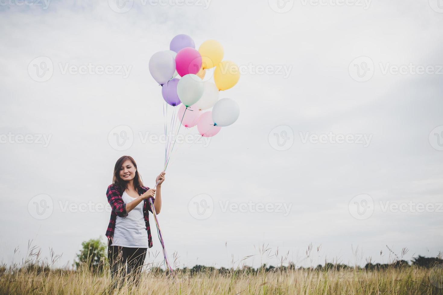 vacker ung hipster kvinna med färgglada ballonger utomhus foto