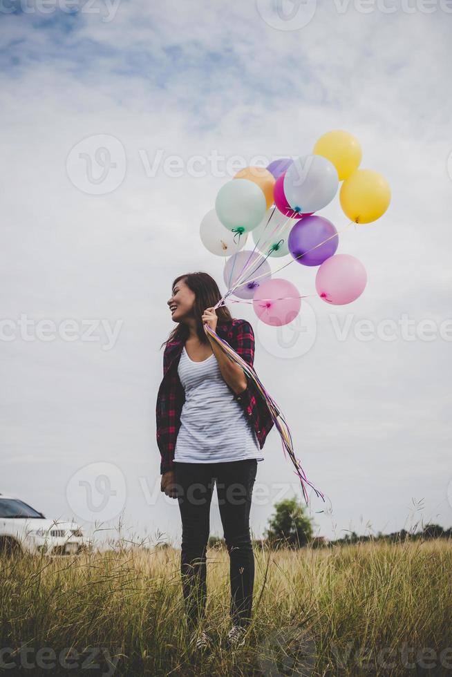 vacker ung hipster kvinna med färgglada ballonger utomhus foto