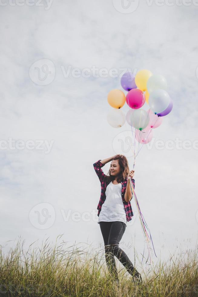 vacker ung hipster kvinna med färgglada ballonger utomhus foto